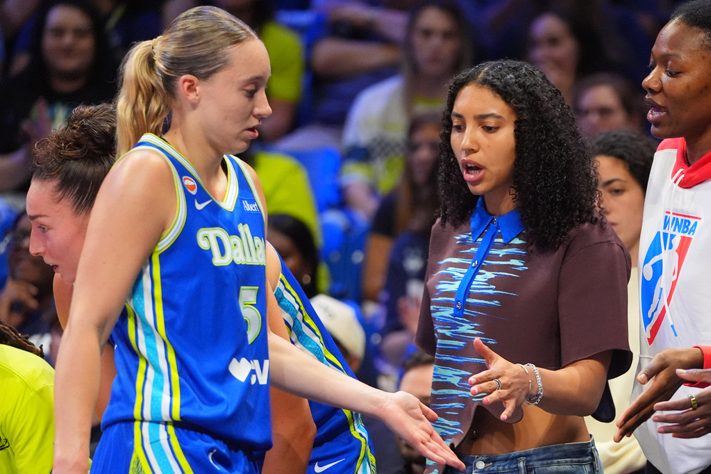 Dallas Wings guard Paige Bueckers (5) gets supports from injured teammate guard Azzi Fudd on the bench during the first half of a WNBA basketball game against the Atlanta Dream in Arlington, Texas, Tuesday, May 12, 2026. (AP Photo/LM Otero)