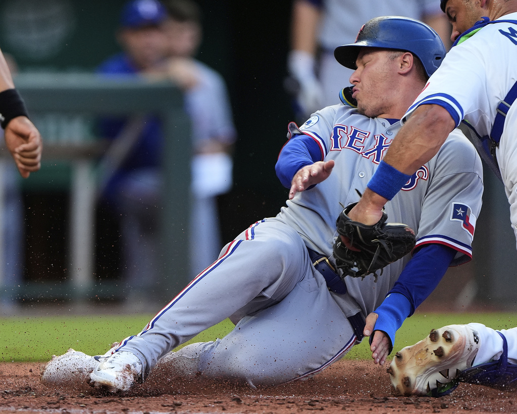 Texas Rangers' Joc Pederson is tagged out by Kansas City Royals catcher Luke Maile as he tried to score on fly out hit by Josh Smith during the second inning of a baseball game Monday, Aug. 18, 2025, in Kansas City, Mo. (AP Photo/Charlie Riedel)