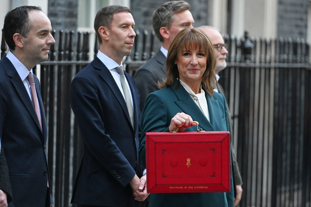 Britain's Chancellor of the Exchequer Rachel Reeves hold up her ministerial red box as she poses with members of her Treasury team on the doorstep of 11 Downing Street,before heading to the House of Commons to deliver her Budget speech in London, Wednesday, Nov. 26, 2025.(AP Photo/Thomas Krych)