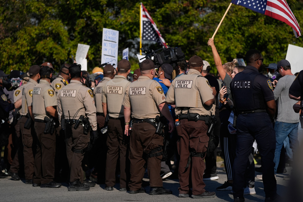 Law enforcement hold back protesters near an Immigration and Customs Enforcement facility in Broadview, Ill., Friday, Oct. 3, 2025. (AP Photo/Erin Hooley))