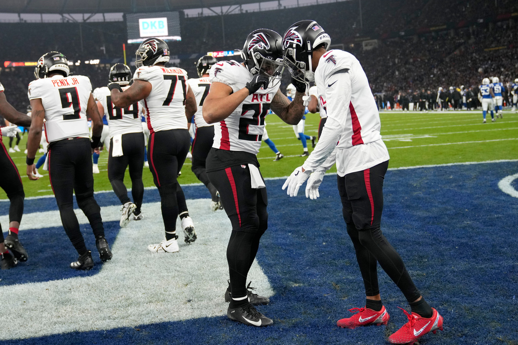 Atlanta Falcons running back Tyler Allgeier (25) celebrates with teammate Darnell Mooney, right, after scoring a touchdown during the first half of an NFL football game against the Indianapolis Colts, Sunday, Nov. 9, 2025, in Berlin, Germany. (AP Photo/Ebrahim Noroozi)