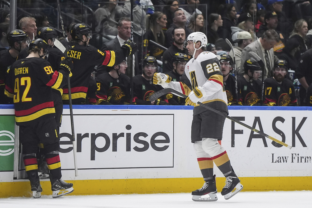 Vegas Golden Knights' Cole Smith (22) celebrates his goal as he skates past the Vancouver Canucks bench during the third period of an NHL hockey game, in Vancouver, British Columbia, Tuesday, April 7, 2026. (Darryl Dyck/The Canadian Press via AP)