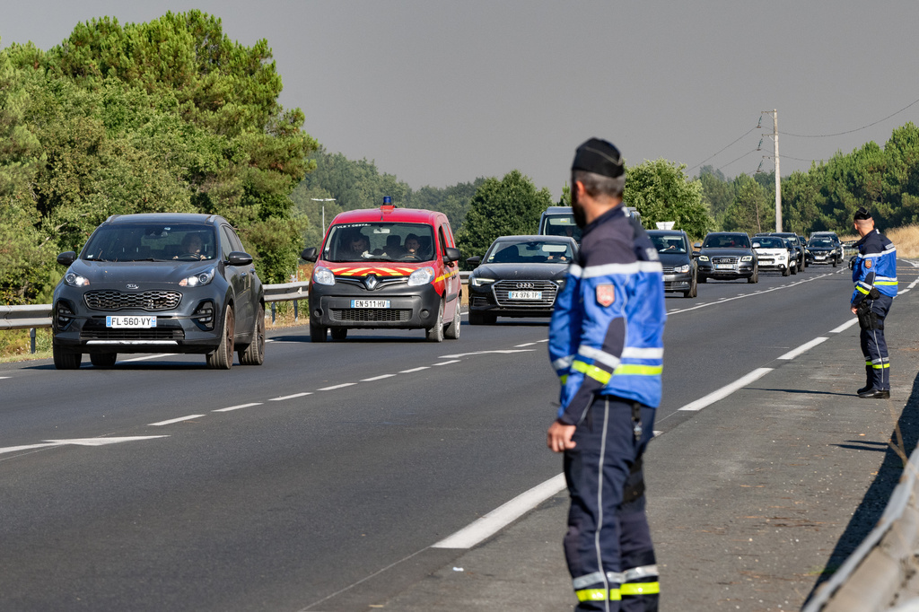 People leave the Ares region during wildfires, western France, Friday July 24, 2026. (AP Photo/Caroline Blumberg)