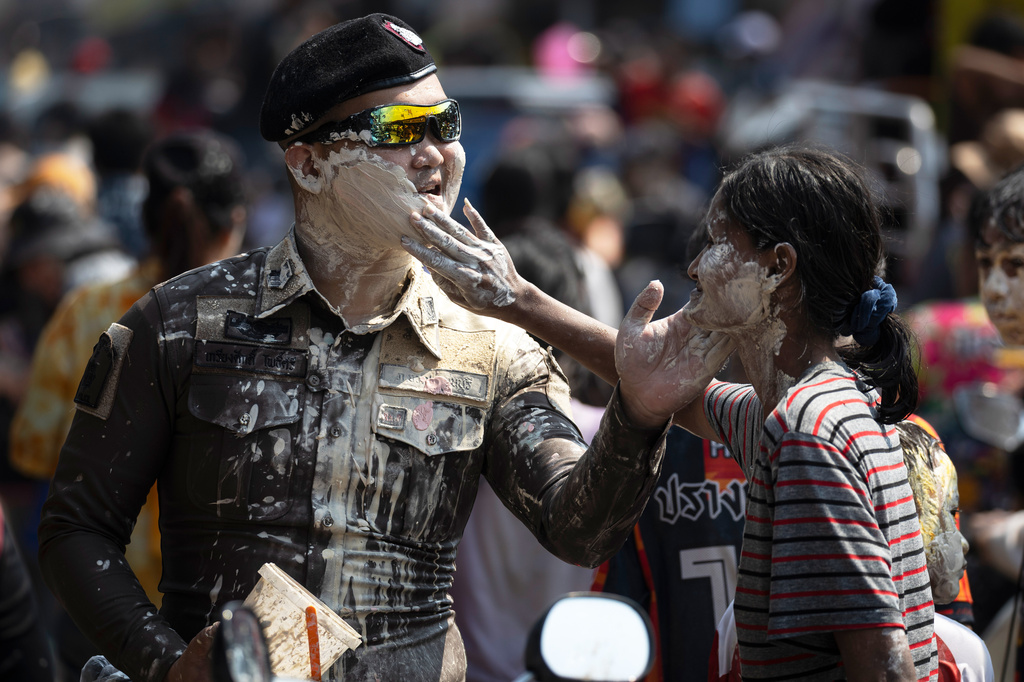 A participant puts powder on the face of a Thai police during the Songkran water festival to celebrate the Thai New Year in Prachinburi province, Thailand, Monday, April 13, 2026. (AP Photo/Wason Wanichakorn)