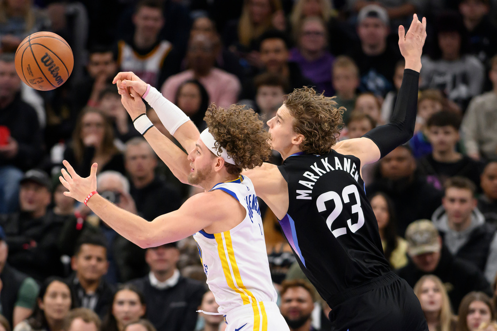 Golden State Warriors guard Brandin Podziemski, left, and Utah Jazz forward Lauri Markkanen, right, fight for possession of the loose ball during the first half of an NBA basketball game, Wednesday, Jan. 28, 2026, in Salt Lake City. (AP Photo/Tyler Tate)