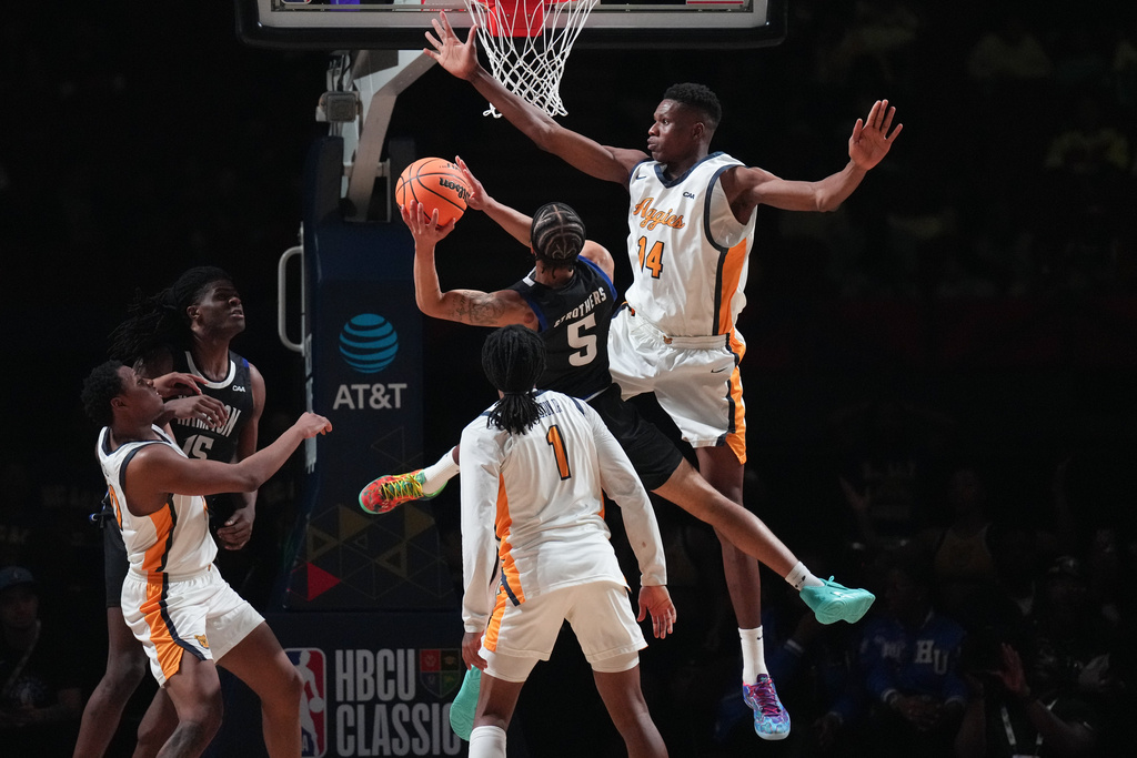 Hampton guard Etienne Strothers (5) goes up for a basket under pressure by North Carolina A&T forward Amadou Doumbia (14) during the first half of an HBCU Classic NCAA college basketball game Friday, Feb. 13, 2026, in Inglewood, Calif. (AP Photo/Jae C. Hong)