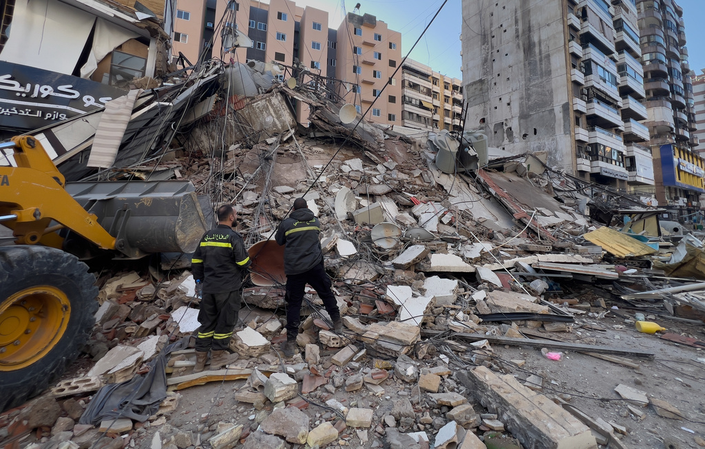 Civil defense workers check a destroyed building that was hit by an Israeli airstrike in Dahiyeh, Beirut's southern suburbs, Lebanon, Tuesday, March 24, 2026. (AP Photo/Hussein Malla)