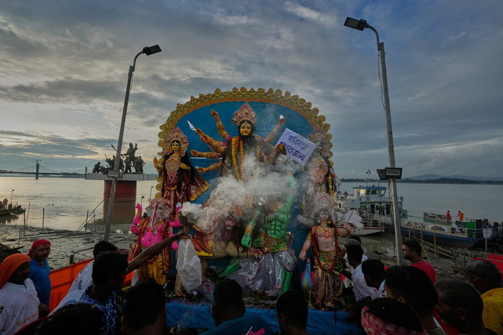 Devotees carry an idol of Hindu goddess Durga to emmers in river Brahmaputra in Guwahati, Thursday, Oct. 2, 2025. (AP Photo/Anupam Nath)