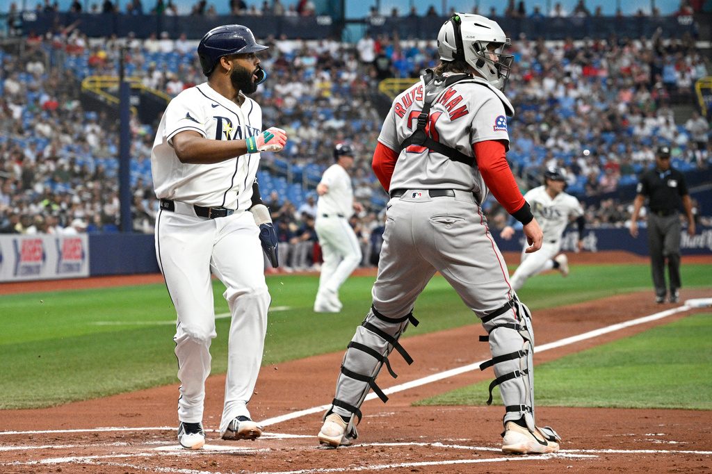 Tampa Bay Rays' Junior Caminero, left, scores off a single hit by Chandler Simpson as Boston Red Sox catcher Adley Rutschman, right, looks on during the first inning of a baseball game, Sunday, Sept. 20, 2026, in St. Petersburg, Fla. (AP Photo/Phelan M. Ebenhack)