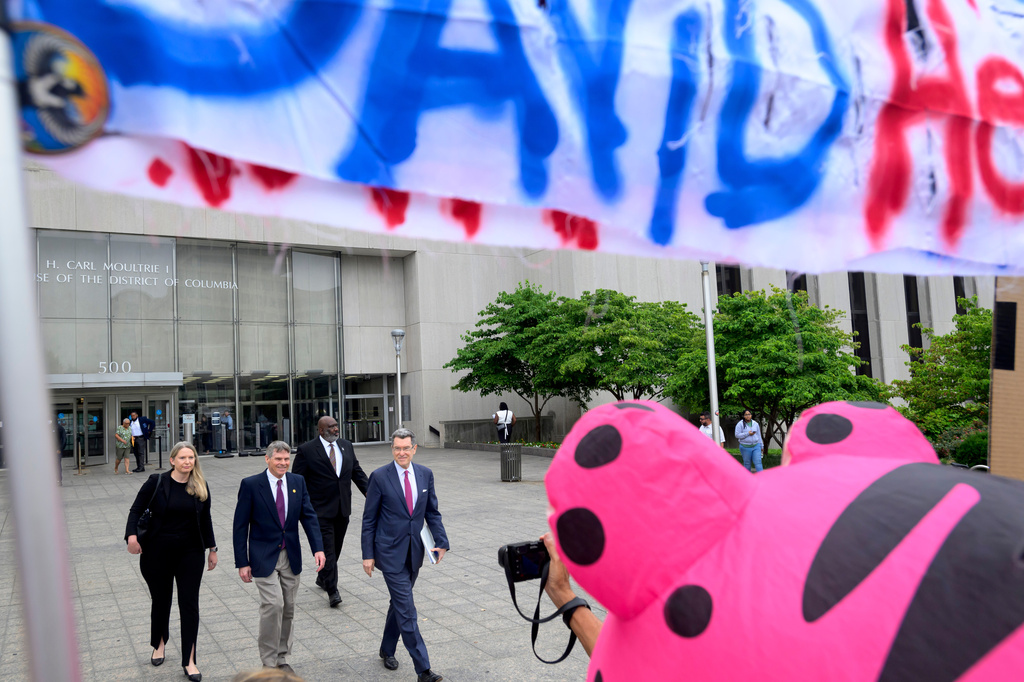 Former Olympic canoeist David Hearn, second from left, with his attorney Norman Eisen, right, depart the D.C. Superior Court after pleading not guilty to allegedly damaging the Lincoln Memorial Reflecting Pool, Thursday, July 9, 2026, in Washington. (AP Photo/Rod Lamkey, Jr.)