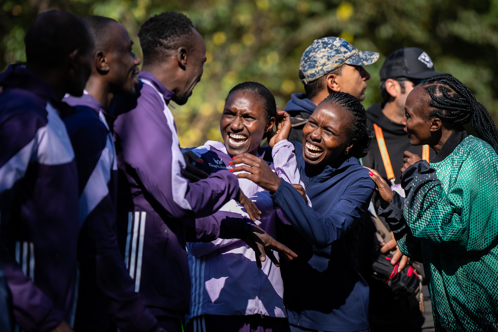 The six winners of the men's and women's elite divisions, celebrate together before the medal ceremony after winning the New York City Marathon, Sunday, Nov. 2, 2025, in New York. (AP Photo/Angelina Katsanis)