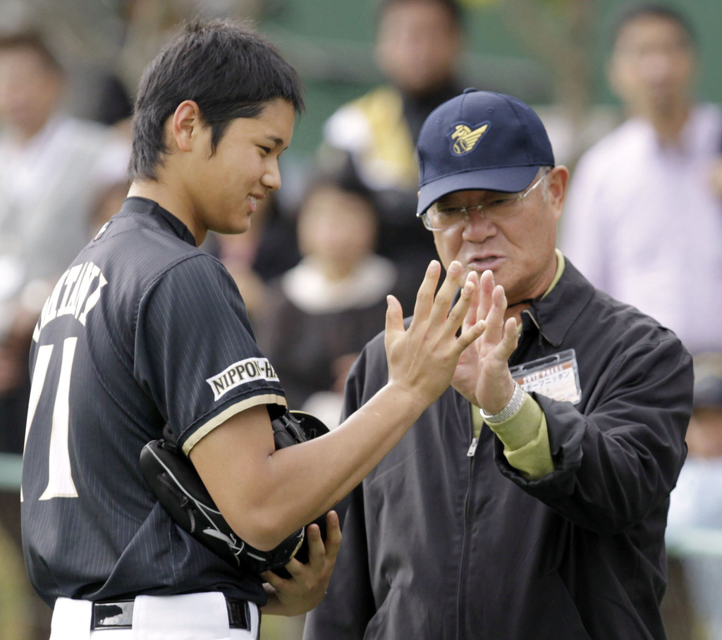 Former professional baseball player Isao Harimoto, right, compares the size of his hand with Hokkaido Nippon-Ham Fighters player Shohei Ohtani, in Kunigami, Okinawa Prefecture, Japan, Feb. 2013. (Kyodo News via AP)