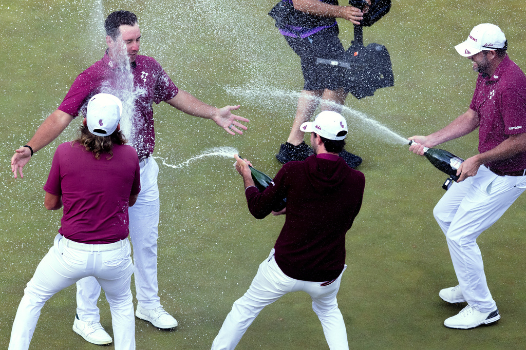 First-place individual champion Lucas Herbert, top left, of Ripper GC, and Marc Leishman, also of Ripper GC, David Puig, of Fireballs GC, and Ripper GC captain Cameron Smith celebrate on the 18th green during the final round of the LIV Golf Virginia golf tournament at Trump National Golf Club, Sunday, May 10, 2026, in Sterling, Va. (Mike Stobe/LIV Golf) CORRECTION: Corrects teams and removes "first-place team champions."