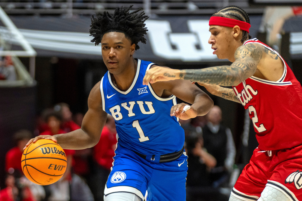 BYU guard Robert Wright III (1) drives with the ball as Utah guard Terrence Brown (2) defends during the first half of an NCAA college basketball game Saturday, Jan. 10, 2026, in Salt Lake City. (AP Photo/Rick Egan)