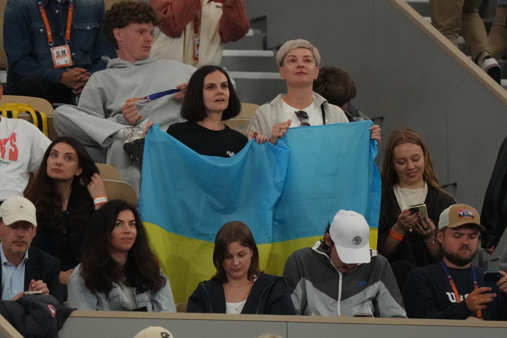 Fans hold Ukrainian flag during the quarterfinal tennis match between Ukraine's Marta Kostyuk and Ukraine's Elina Svitolina at the French Open in Paris, Tuesday, June 2, 2026. (AP Photo/Aurelien Morissard)