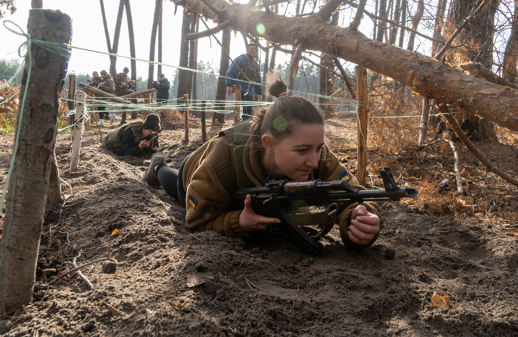 Civilians practice military skills on a training ground in Kharkiv region, Ukraine, Saturday, Nov. 15, 2025. (AP Photo/Andrii Marienko)