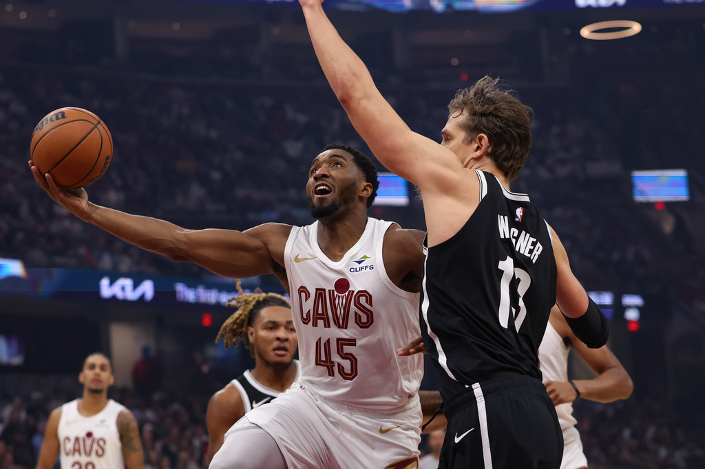 Cleveland Cavaliers guard Donovan Mitchell (45) shoots over Brooklyn Nets center Moritz Wagner (13) in the first half of an NBA basketball game in Cleveland, Saturday, Oct. 24, 2026. (AP Photo/Tim Phillis)