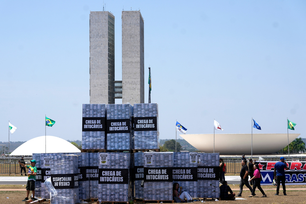Boxes symbolizing money are displayed outside Congress to protest alleged corruption in the Supreme Court during a protest by supporters of presidential candidate Sen. Flavio Bolsonaro calling for the impeachment of Supreme Court Justice Alexandre de Moraes in Brasilia, Brazil, Tuesday, Sept. 15, 2026. (AP Photo/Eraldo Peres)