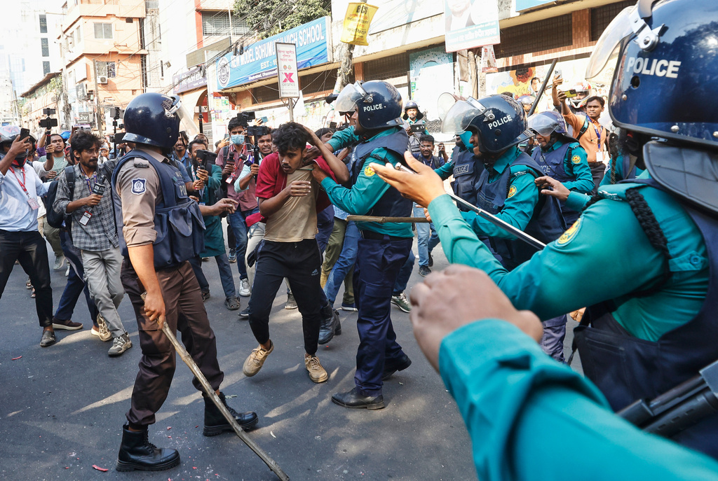Police use baton to disperse protesters gather outside the demolished residence of Sheikh Mujibur Rahman, Bangladesh's former leader and the father of the country's ousted Prime Minister Sheikh Hasina after the verdict against Hasina, in Dhaka, Bangladesh, Monday, Nov. 17, 2025. (AP Photo/ Rajib Dhar)