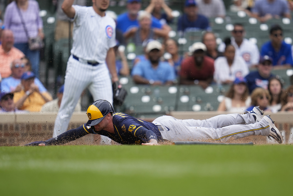 Milwaukee Brewers' Brice Turang (2) scores on a single by Sal Frelick during the sixth inning in the first baseball game of a doubleheader, against the Chicago Cubs, Tuesday, Aug. 19, 2025, in Chicago. (AP Photo/Erin Hooley)