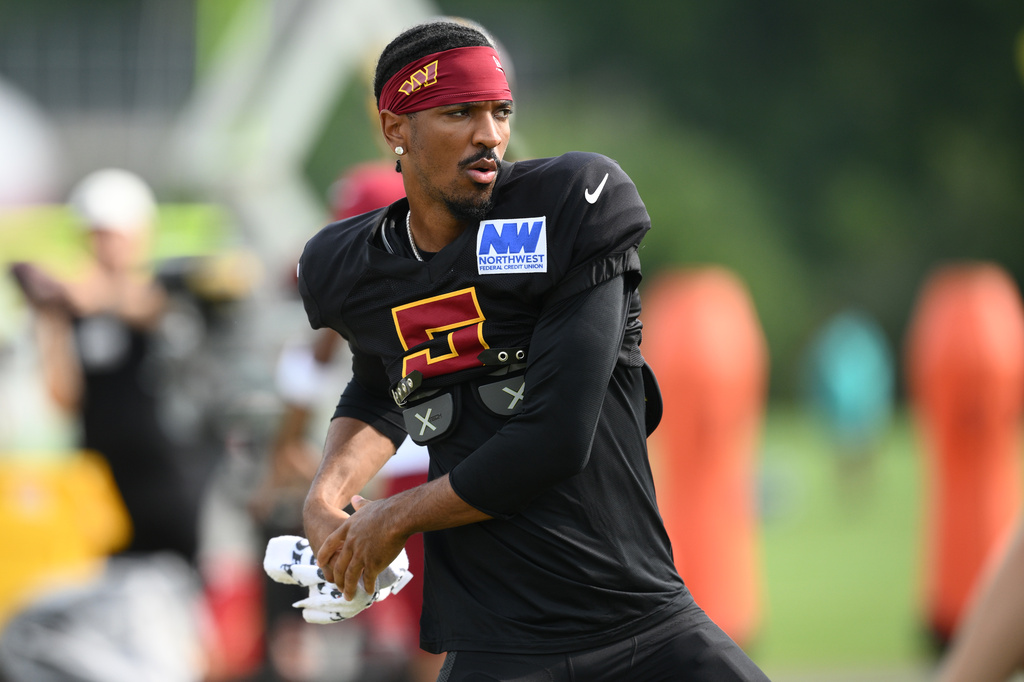 Washington Commanders quarterback Jayden Daniels works out before a joint practice with the Miami Dolphins at NFL football training camp, Wednesday, Aug. 12, 2026 in Ashburn, Va. (AP Photo/Nick Wass)