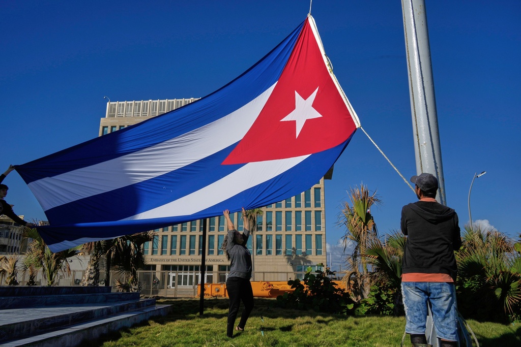 Workers fly the Cuban flag at half-staff at the Anti-Imperialist Tribune near the U.S. Embassy in Havana, Cuba, Monday, Jan. 5, 2026, in memory of Cubans who died two days before in Caracas, Venezuela during the capture of Venezuelan President Nicolas Maduro by U.S. forces. (AP Photo/Ramon Espinosa)