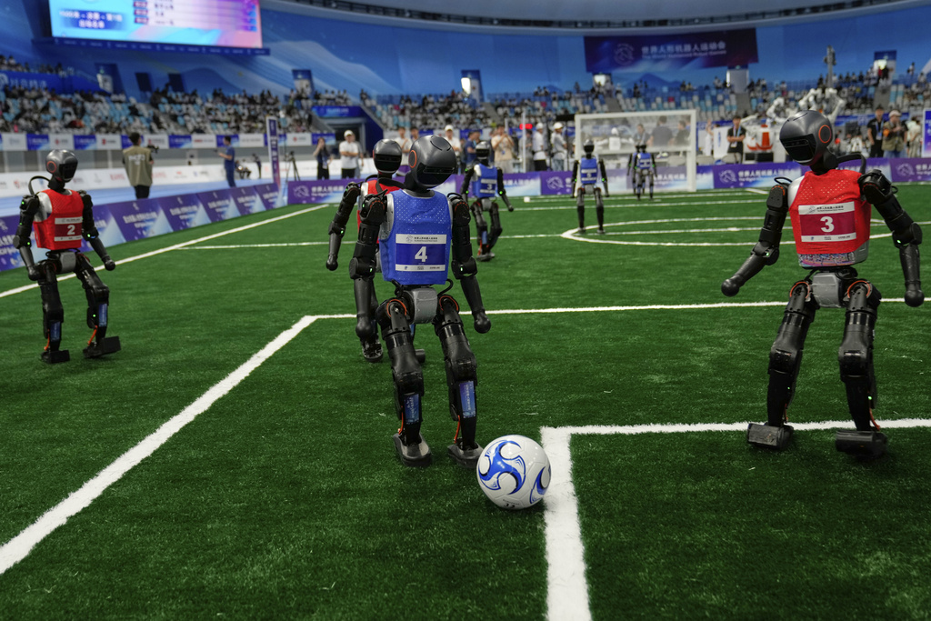 Robots play soccer at the World Humanoid Robot Games in Beijing, China, Friday, Aug. 15, 2025. (AP Photo/Mahesh Kumar A.)