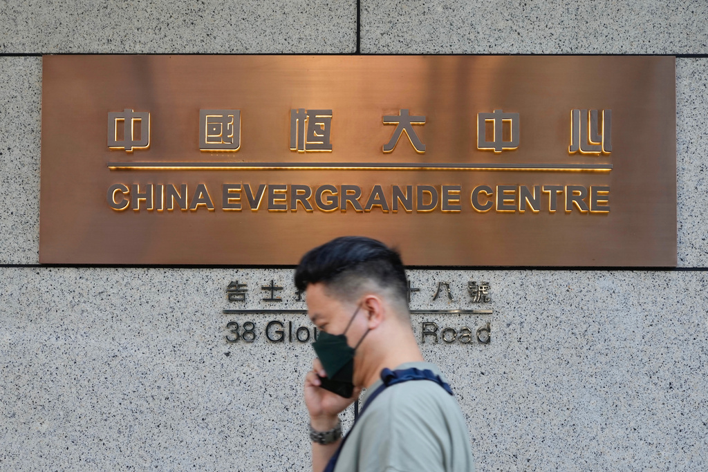 FILE - A man walks past the entrance of the headquarters of China Evergrande Group in Hong Kong Monday, Oct. 4, 2021. (AP Photo/Vincent Yu, File)