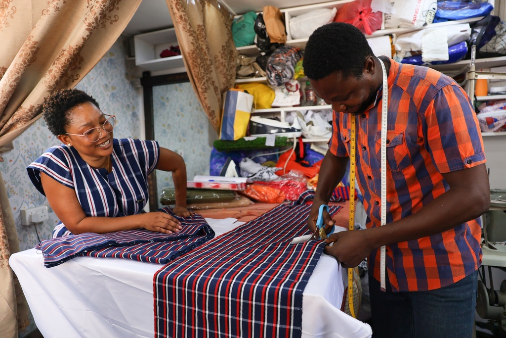 Perfectual Linnan, a fashion designer, interacts with a staff member at her workshop in Accra, Ghana, Wednesday, Feb. 18, 2026. (AP Photo/Tsraha Yaw)