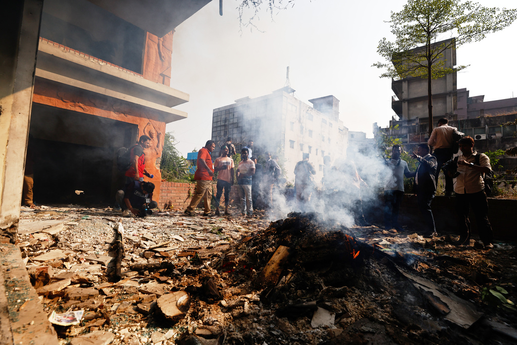 A fire smolders after the party office of the Awami League party led by ousted Prime Minister Sheikh Hasina was vandalized during a nationwide "lockdown" called by Hasina's party in protest against her trial, in Dhaka, Bangladesh, Thursday, Nov. 13, 2025. (AP Photo/Mahmud Hossain Opu)