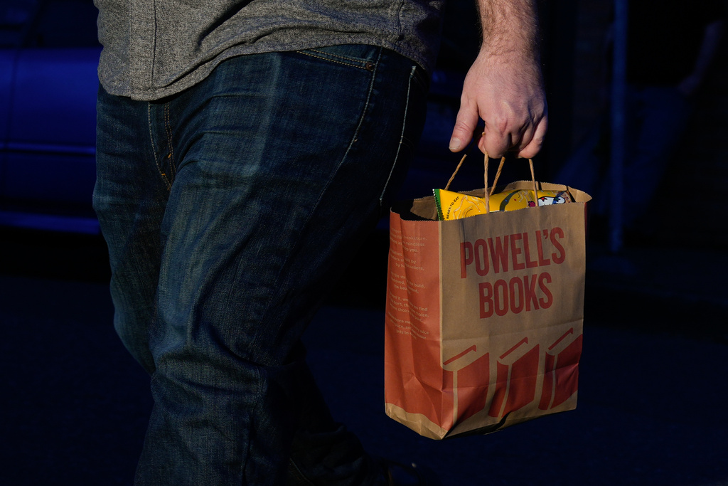A shopper carries a Powell's Books bag on Monday, March 16, 2026, in Portland, Ore. (AP Photo/Jenny Kane)
