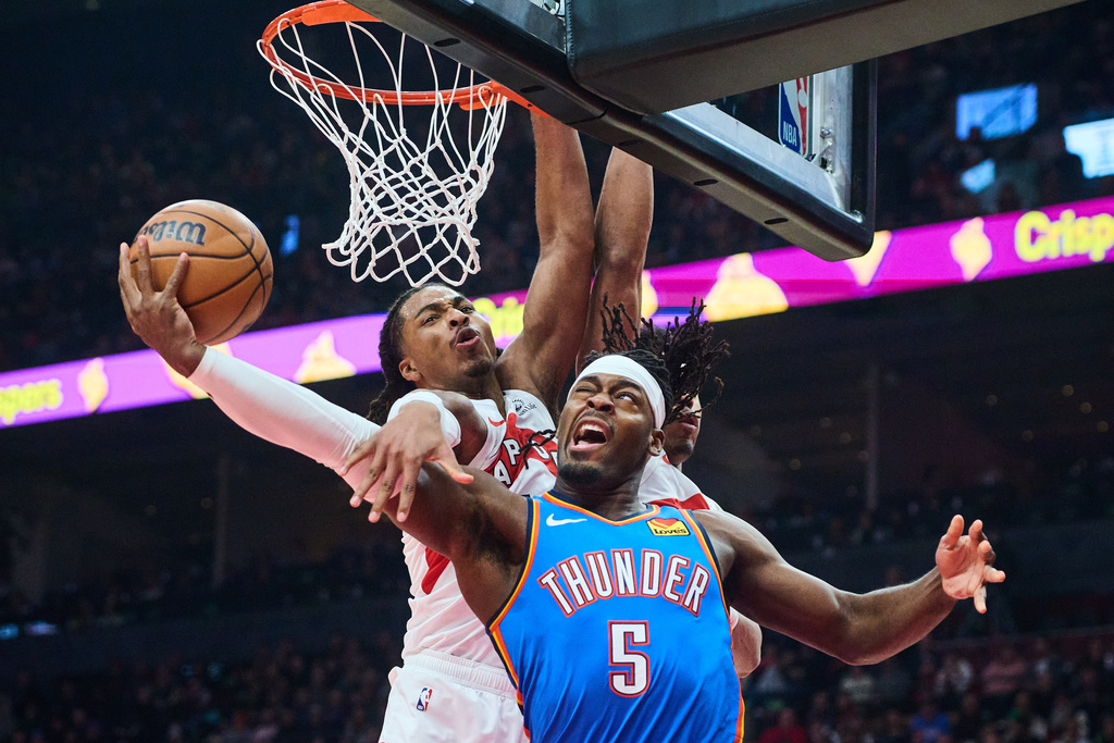 Oklahoma City Thunder's Luguentz Dort (5) is stopped at the net by Toronto Raptors' Collin Murray-Boyles during the first half of an NBA basketball game in Toronto, on Tuesday, Feb. 24, 2026. (Sammy Kogan/The Canadian Press via AP)