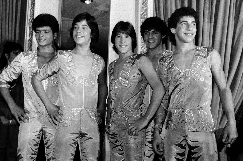 FILE - Members of the music group "Menudo," from left, Robby Rosa (Draco Rosa), Ray Reyes, Roy Roselló, Charlie Massó and Ricky Meléndez pose during a reception in their honor in New York on Feb. 10, 1984. (AP Photo/Richard Drew, File)