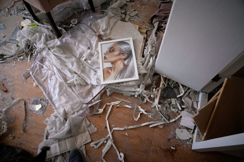 A painting lies on the floor of a residential building damaged by recent U.S.-Israeli strikes in Fardis, west of Tehran, Iran, Friday, April 3, 2026. (AP Photo/Vahid Salemi)