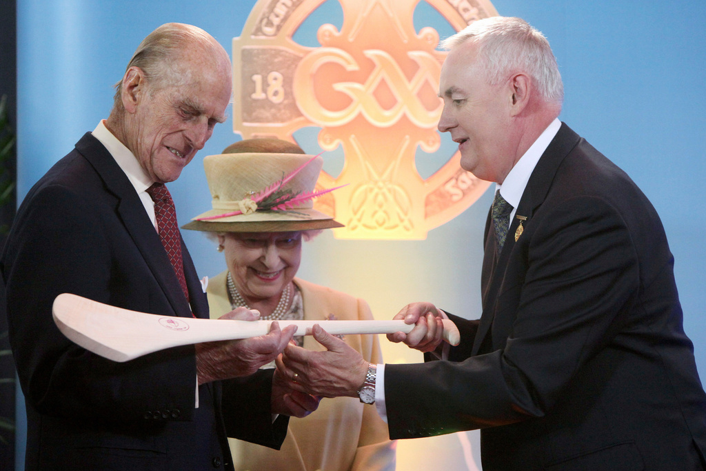 FILE - Britain's Queen Elizabeth II and her husband Prince Philip, Duke of Edinburgh, admire a hurley passed to them by the President of the Gaelic Athletic Association, Christy Cooney, during a tour of Croke Park, Dublin, during the second day of their state visit to Ireland. (Pool Photo via AP, File)