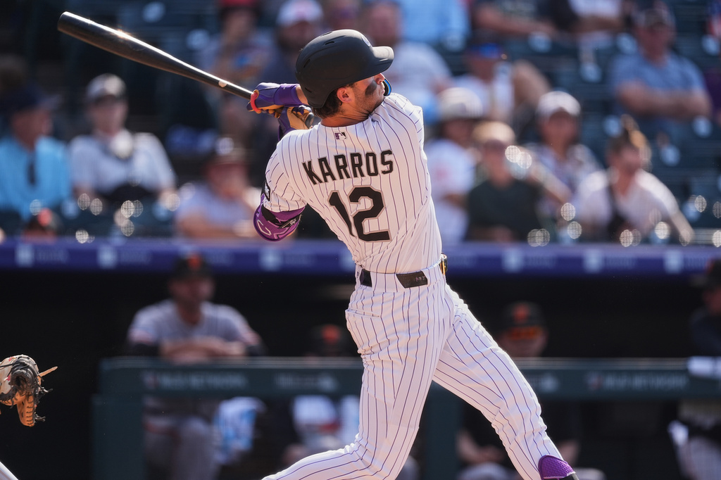 Colorado Rockies' Kyle Karros follows the flight of his three-run home run off San Francisco Giants relief pitcher Dylan Smith in the eighth inning of a baseball game Sunday, July 5, 2026, in Denver. (AP Photo/David Zalubowski)