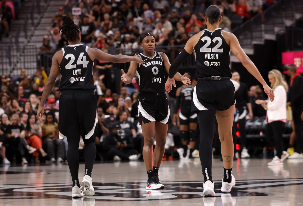 Las Vegas Aces guard Jackie Young (0) is congratulated by guard Jewell Loyd (24) and center A'ja Wilson (22) after making a 3-point basket against the Chicago Sky during the first half of a WNBA basketball game Tuesday, Sept. 9, 2025, in Las Vegas. (Steve Marcus/Las Vegas Sun via AP)