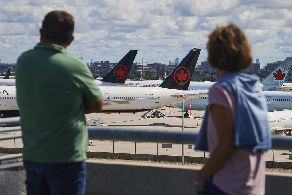 Travelers look out over grounded Air Canada planes as flight attendants picket at Pearson International Airport in Toronto, Monday, Aug. 18, 2025. (Sammy Kogan/The Canadian Press via AP)