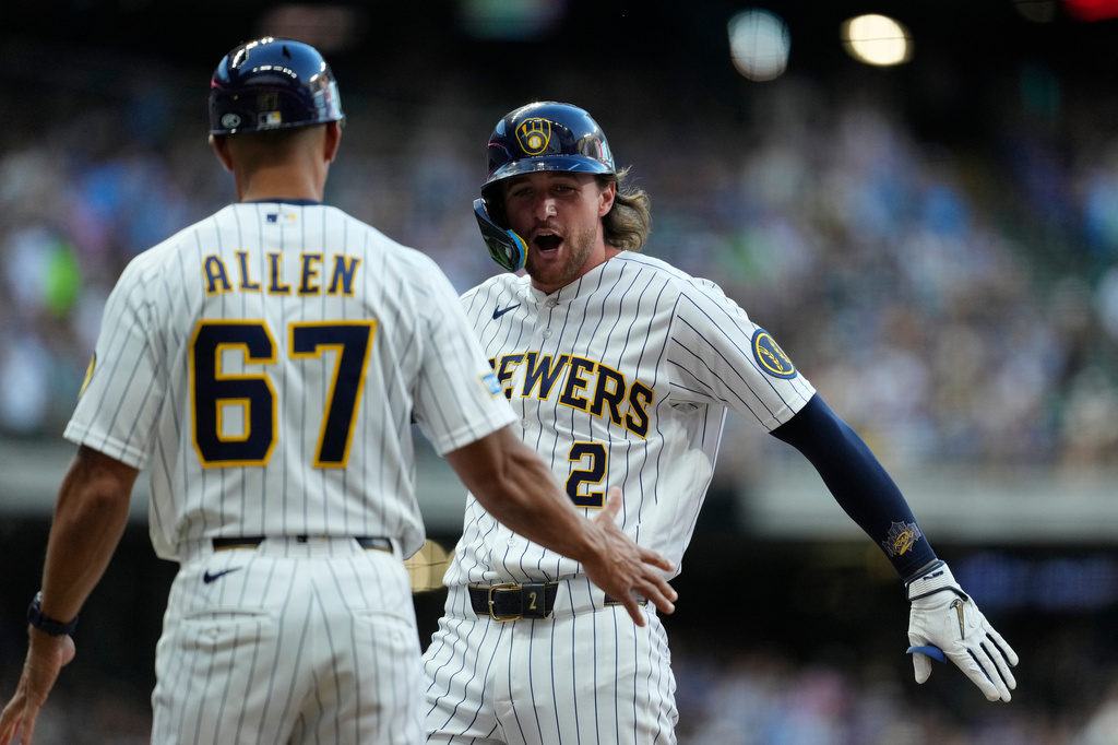 Milwaukee Brewers' Brice Turang (2) celebrates with first base coach Spencer Allen (67) after hitting a two-run single during the fourth inning of a baseball game against the Minnesota Twins, Saturday, Aug. 8, 2026, in Milwaukee. (AP Photo/Aaron Gash)