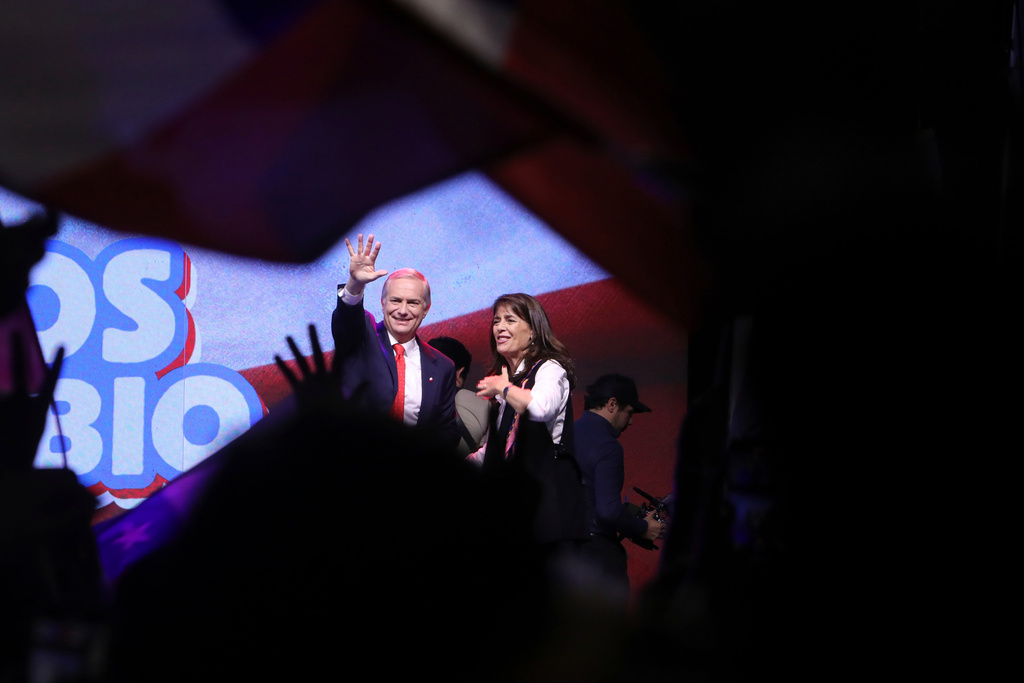 Presidential candidate Jose Antonio Kast of the Republican Party, accompanied by his wife Maria Pia Adriasola, waves to supporters after early results in the general elections in Santiago, Chile, Sunday, Nov. 16, 2025. (AP Photo/Cristobal Escobar)