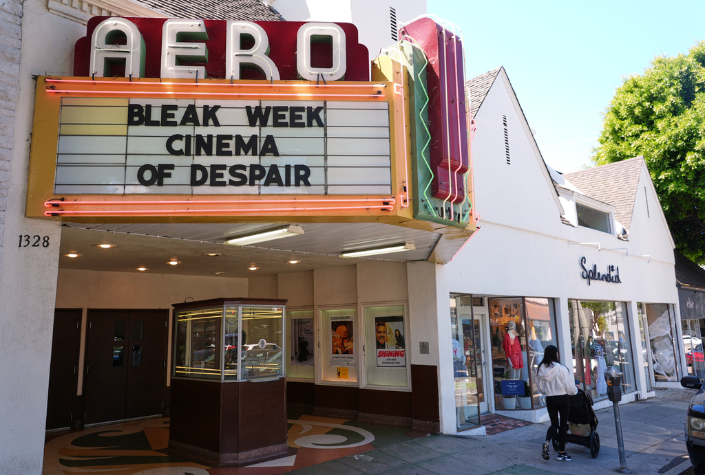 A woman pushes a stroller past the marquee of the Aero Theatre, one of the venues hosting the "Bleak Week: Cinema of Despair" film festival, Friday, May 29, 2026, in Santa Monica, Calif. (AP Photo/Chris Pizzello)