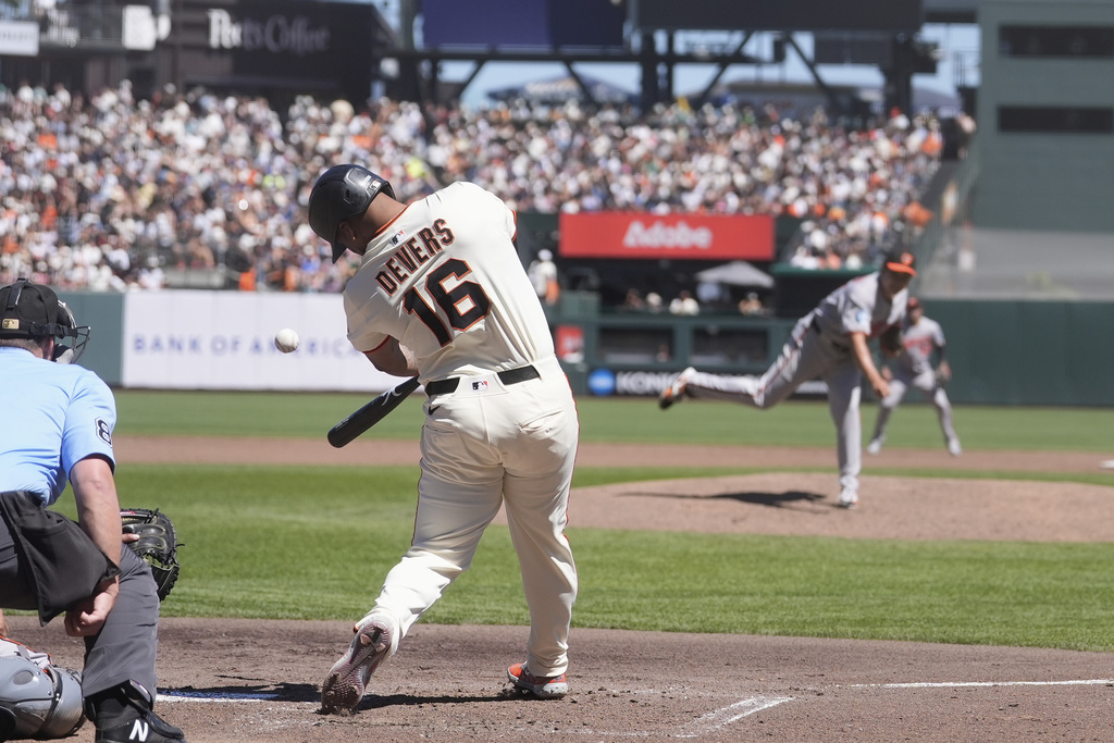 San Francisco Giants' Rafael Devers (16) hits an RBI single off of Baltimore Orioles pitcher Tomoyuki Sugano, middle right, during the third inning of a baseball game in San Francisco, Sunday, Aug. 31, 2025. (AP Photo/Jeff Chiu)