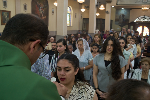 Catholic parish priest Bashar Fawadleh offers a communion wafer to a faithful during Mass at Christ the Redeemer Church in the West Bank village of Taybeh, Sept. 28, 2025. (AP Photo/Leo Correa) Catholic parish priest Bashar Fawadleh offers a communion wafer to a faithful during Mass at Christ the Redeemer Church in the West Bank village of Taybeh, Sept. 28, 2025. (AP Photo/Leo Correa)