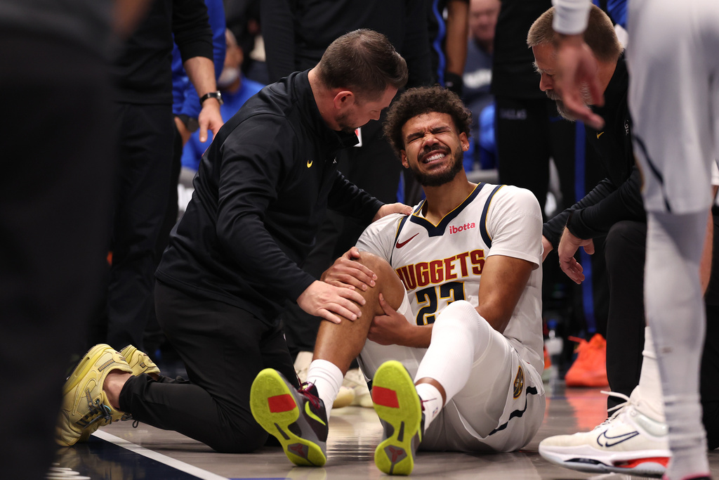 Denver Nuggets forward Cameron Johnson reacts after sustaining an injury during the fourth quarter of an NBA basketball game against the Dallas Mavericks Tuesday, Dec. 23, 2025, in Dallas. (AP Photo/Sam Hodde)