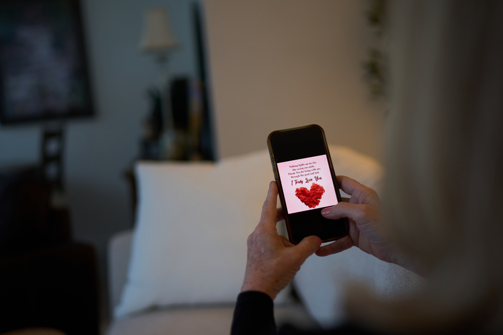 Debra Fox, who had $58,000 stolen from her in a romance scam, looks at a message on her phone that her scammer sent as she sits at home, Wednesday, May 13, 2026, in Arvada, Colo. (AP Photo/David Goldman)