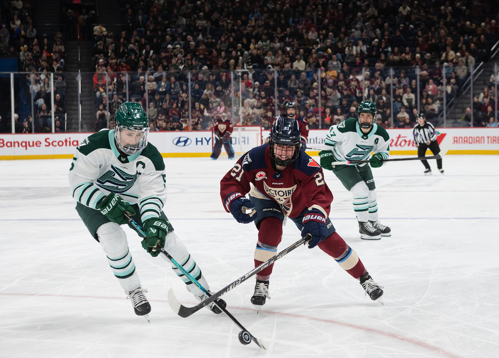 Boston Fleet's Megan Keller (5) skates in to take the puck from Montreal Victoire's Maureen Murphy (21) during second-period PWHL hockey game action in Laval, Quebec, Sunday March 15, 2026. (Peter McCabe/The Canadian Press via AP)