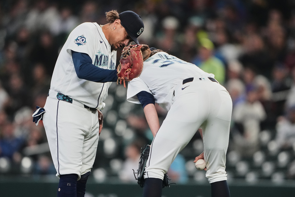 Seattle Mariners first baseman Josh Naylor checks on starting pitcher Logan Gilbert after Athletics' Carlos Cortes hit a line drive into his jersey during the first inning of a baseball game, Wednesday, April 22, 2026, in Seattle. (AP Photo/Lindsey Wasson)