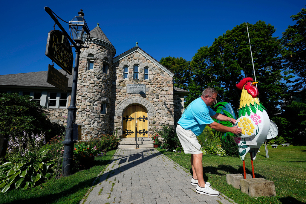 David LeBlanc sets up a rooster in front of the Memorial Library in Ogunquit, Maine, Thursday, July 23, 2026. (AP Photo/Robert F. Bukaty)
