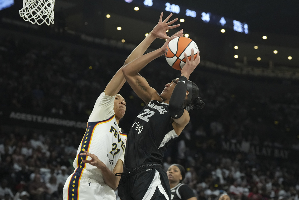 Las Vegas Aces center A'ja Wilson (22) looks to shoot against Indiana Fever forward Makayla Timpson, left, in the first half of Game 1 of a WNBA basketball playoff semifinals series Sunday, Sept. 21, 2025, in Las Vegas. (AP Photo/Candice Ward)