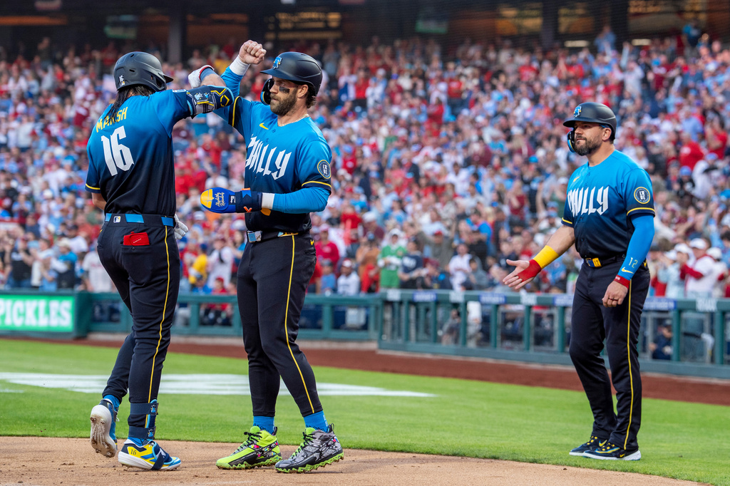 Philadelphia Phillies' Brandon Marsh, left, celebrates after his three-run home run with Bryce Harper, center, and Kyle Schwarber, right, during the first inning of a baseball game against the Arizona Diamondbacks, Friday, April 10, 2026, in Philadelphia. (AP Photo/Chris Szagola)